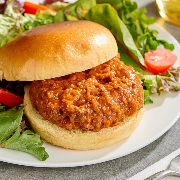 A sandwich with Vanee beef on top served with a salad and water.