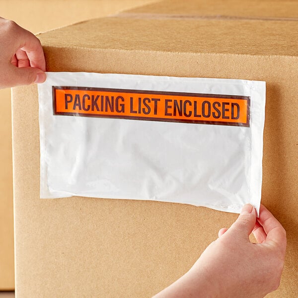 A person putting a Lavex printed polyethylene packing list envelope on a box.