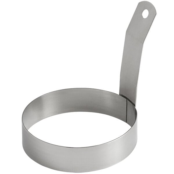 A silver stainless steel egg ring with a handle.