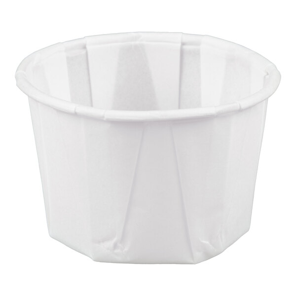 A small white paper souffle or portion cup.