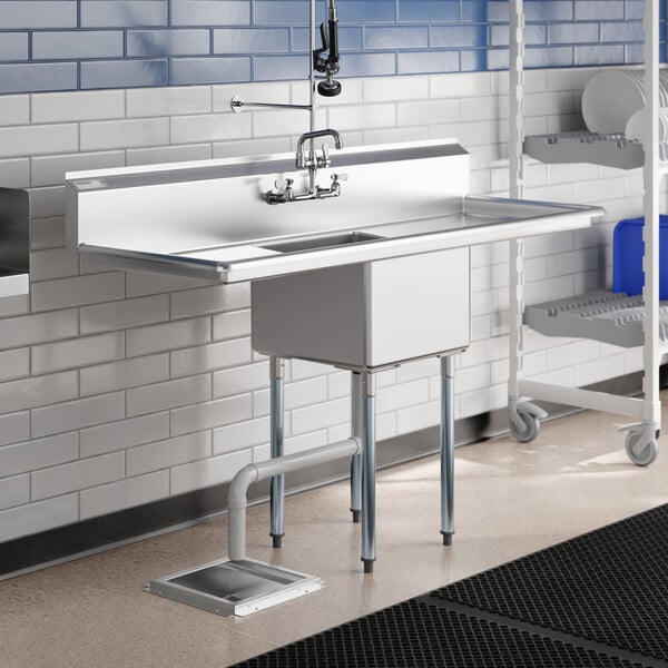 A Regency stainless steel one compartment commercial sink with drainboards on a counter in a kitchen.