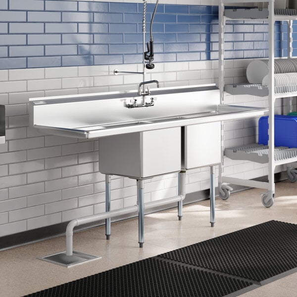 A Regency stainless steel 2 compartment sink with drainboards on a counter.