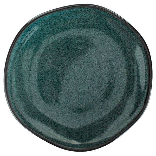 A close up of a dark blue International Tableware Luna porcelain plate with a black rim.