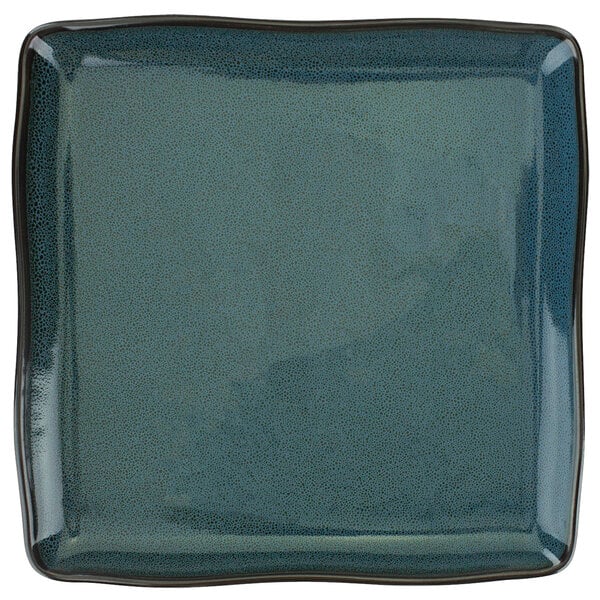 A white square porcelain plate with a speckled midnight blue surface.