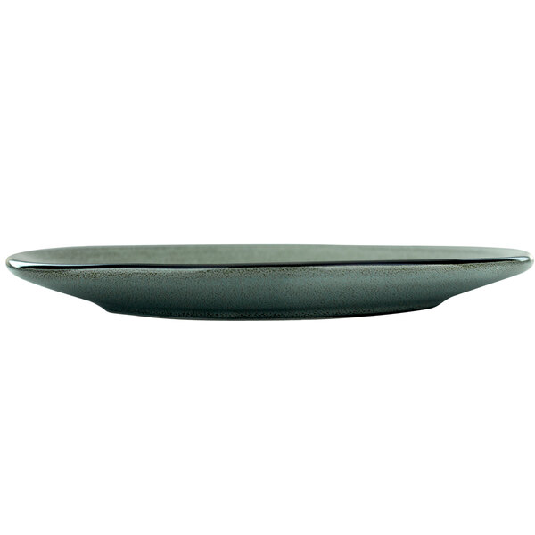 A round ash saucer with a black rim on a table.