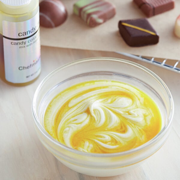 A bowl of food with yellow liquid next to chocolates with a white Chefmaster label.