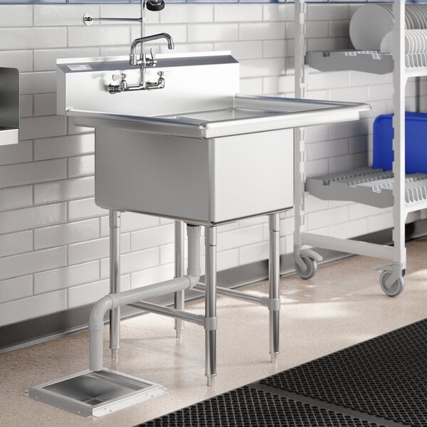 A Regency stainless steel one compartment sink with a right drainboard on a counter in a kitchen.