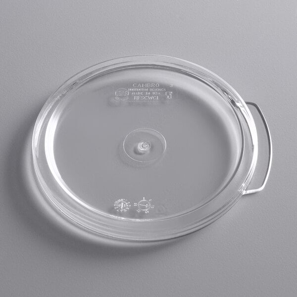 A clear plastic lid for a round food storage container with a handle.