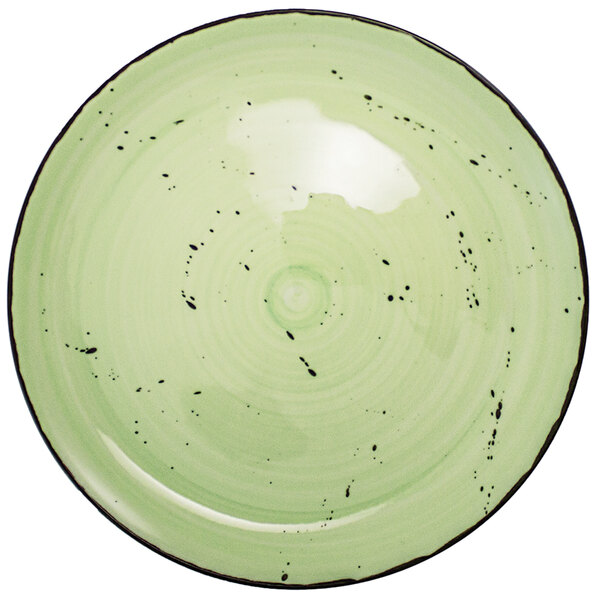 A lime green porcelain plate with black specks.