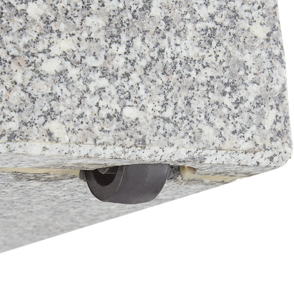 A black circle with a hole in the center on a stone surface.