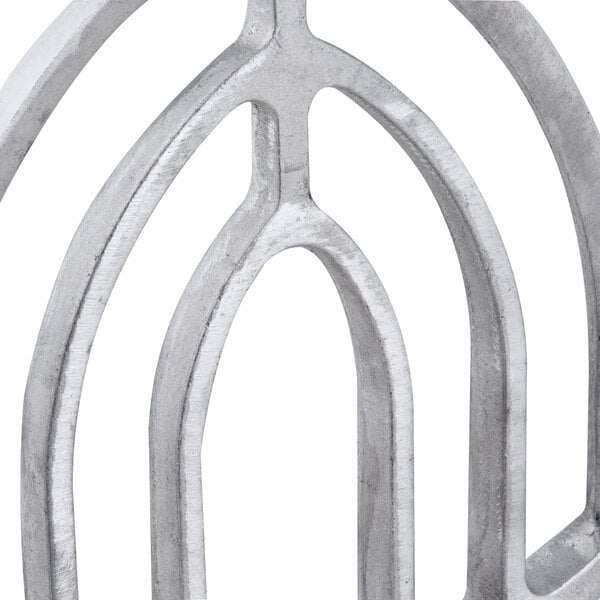 A close up of a metal Hobart flat beater with a circular design.