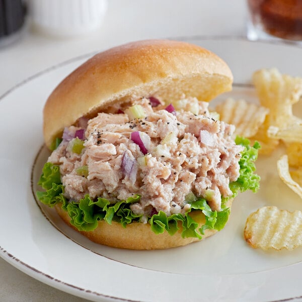 A sandwich on a white plate with Sweet Sue canned chicken on it.