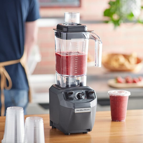 Person using a food blender to make a fruit smoothie