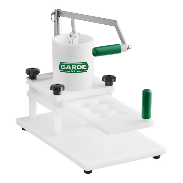 A white machine with a green handle and white base for making sliders.
