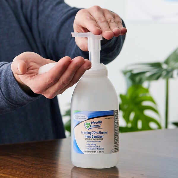 A person using a pump dispenser to use Kutol Health Guard hand sanitizer.