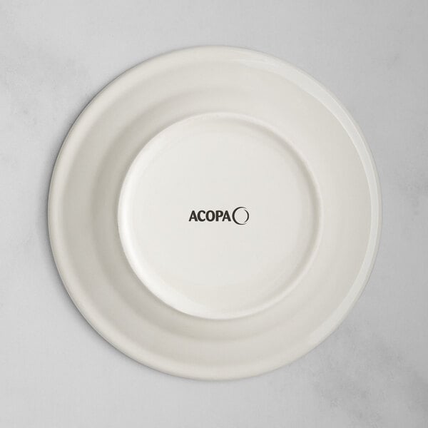 An ivory stoneware plate with blue and black bands and black text on it.