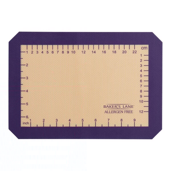 A rectangular purple Baker's Lane silicone baking mat with a ruler on it.