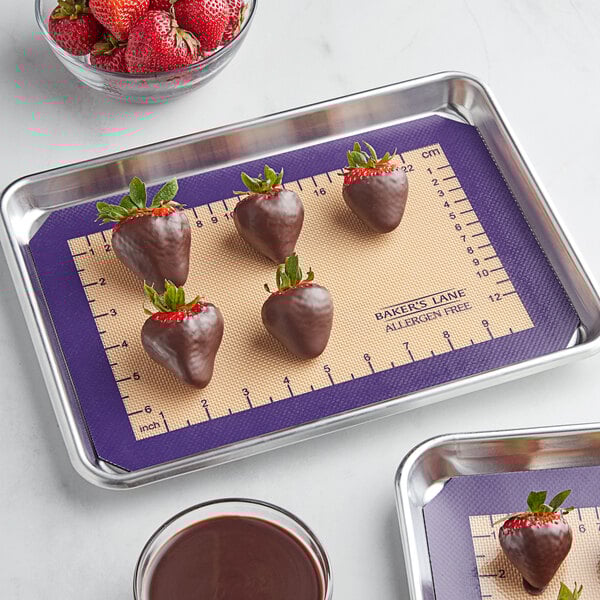 A Baker's Lane purple silicone baking mat with chocolate covered strawberries on a tray.
