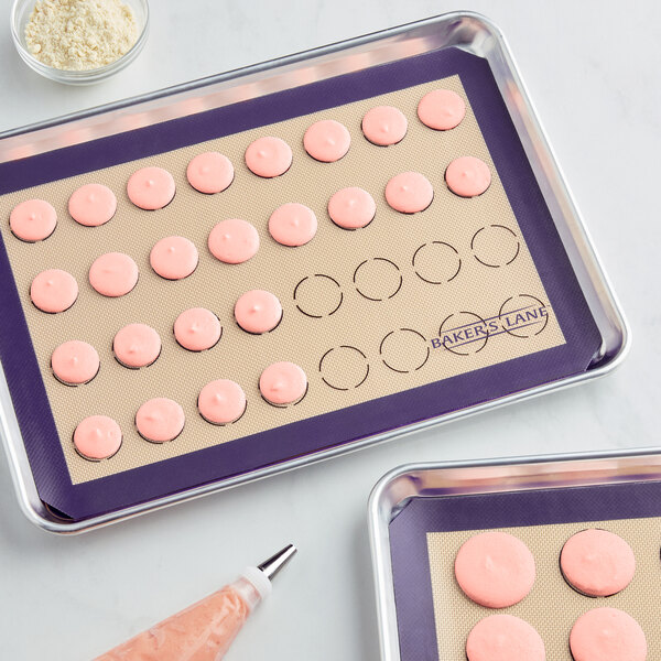 A tray of pink cookies on a Baker's Lane purple silicone baking mat.