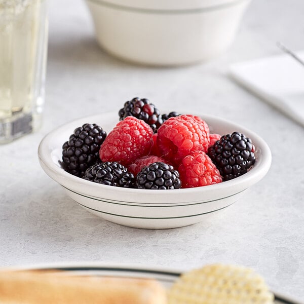 A bowl of raspberries and blackberries on a table.