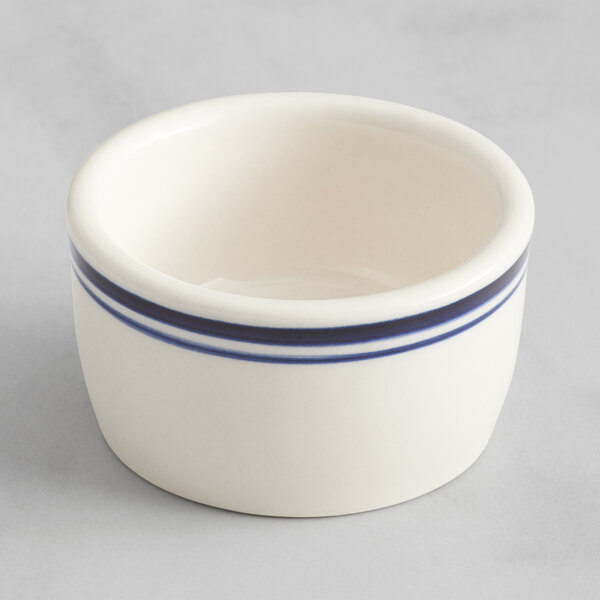 An Acopa ivory stoneware ramekin with a blue stripe.