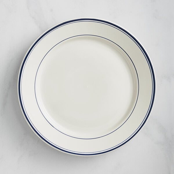 An Acopa ivory stoneware plate with wide rim and blue lines.