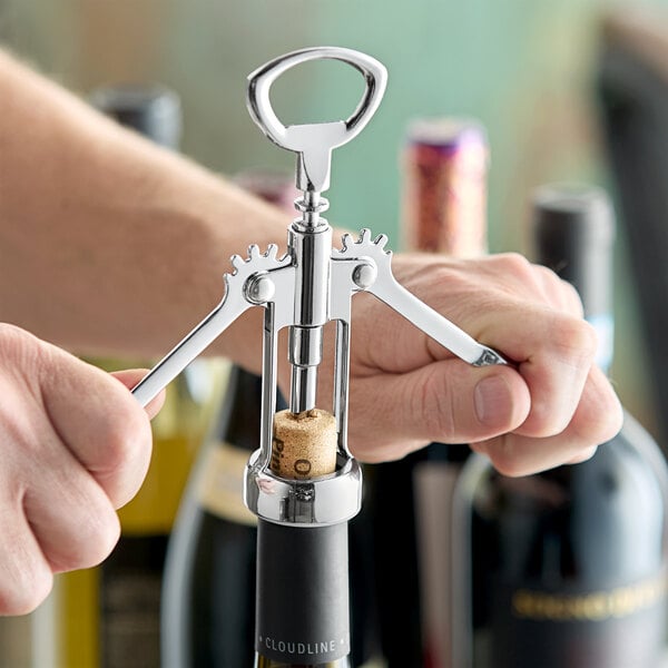 A person using a Choice wing corkscrew to open a bottle of wine with a cork.