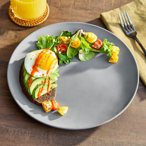 An American Metalcraft matte grey round coupe melamine plate with a salad and toast on it.