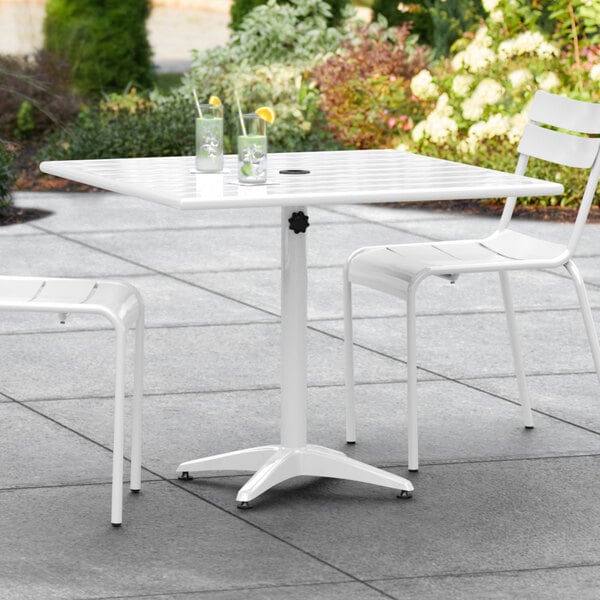 A white table with chairs on an outdoor patio.