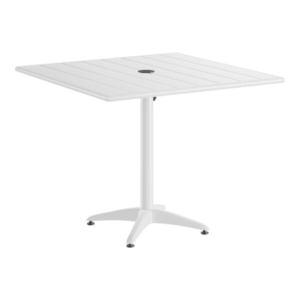A white, square, aluminum outdoor dining table with a central umbrella hole and a four-legged base.