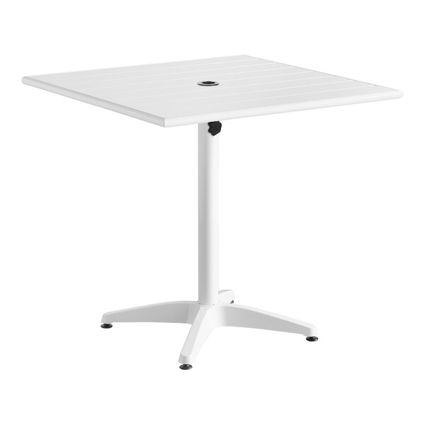 A white square Lancaster Table & Seating aluminum table with a white metal base and a round umbrella hole.