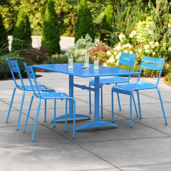 A blue Lancaster Table & Seating outdoor dining table with chairs on a patio.