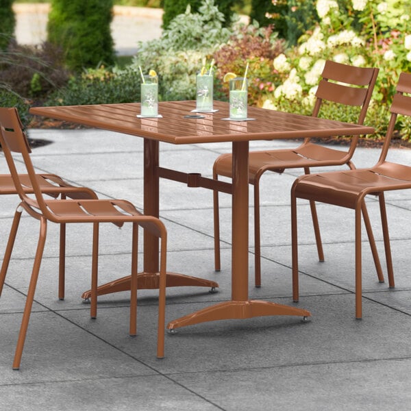 A Lancaster Table & Seating brown outdoor table with drinks on a patio.