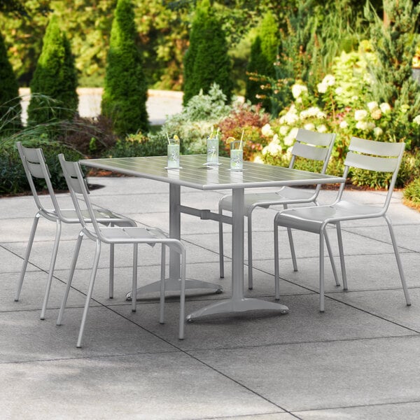 A Lancaster Table & Seating outdoor table with chairs on a patio.