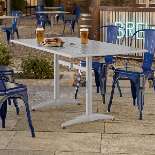 A rectangular silver powder-coated aluminum outdoor dining table with an umbrella hole.