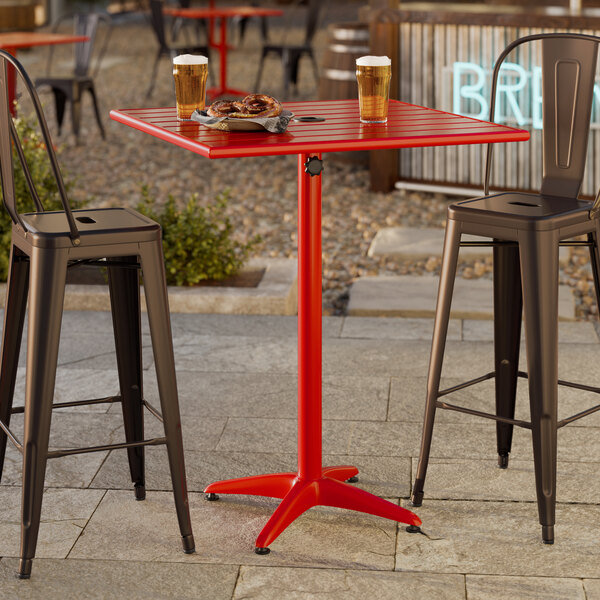 A red powder-coated aluminum bar height outdoor table with an umbrella hole.