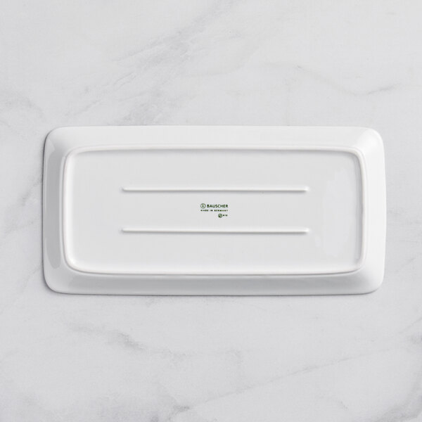 A Bauscher bright white rectangular porcelain platter on a marble surface.