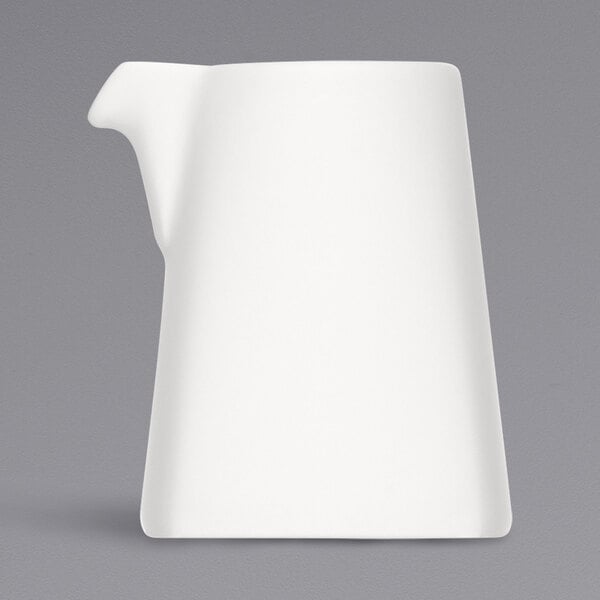 A Bauscher bright white porcelain creamer with a handle.