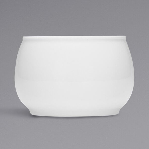 A Bauscher bright white porcelain sugar bowl with a lid on a gray background.