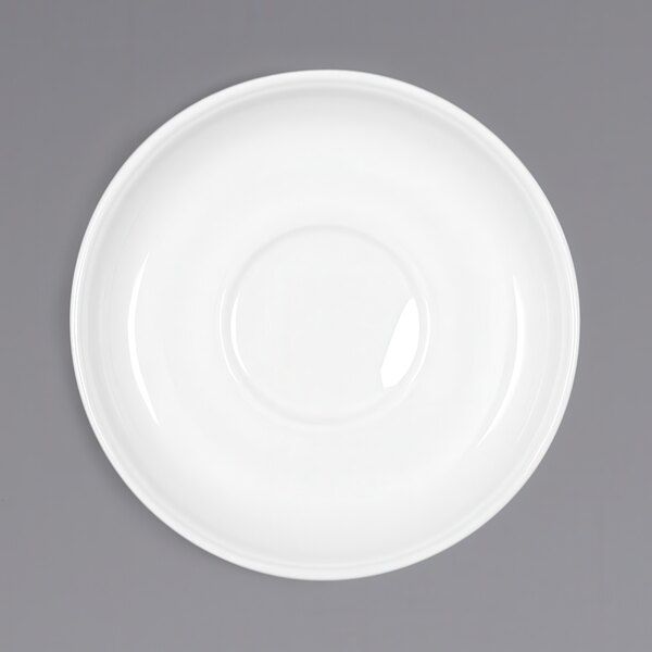 A Bauscher white porcelain saucer with a circular shape on a gray surface.