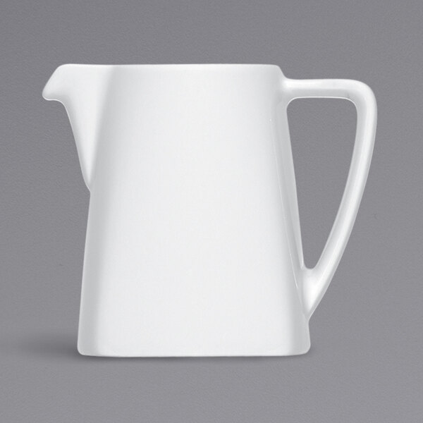 A Bauscher bright white porcelain creamer with a handle.