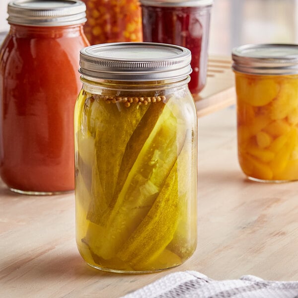 A table with jars of pickled vegetables and fruit.