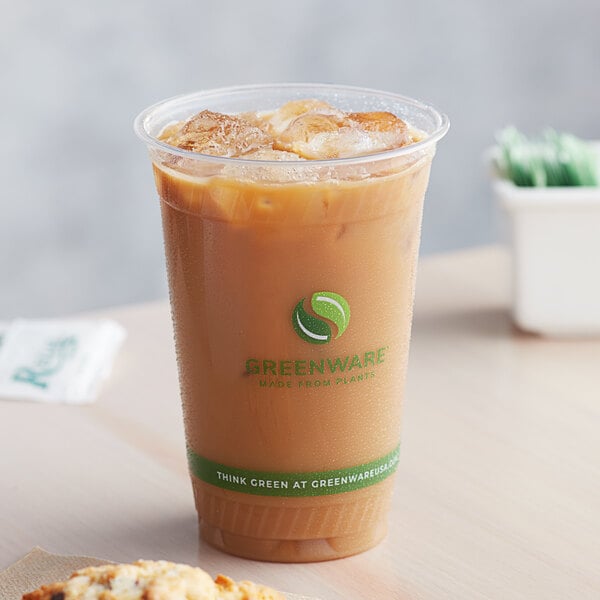 A Fabri-Kal Greenware plastic cup filled with iced coffee on a counter.