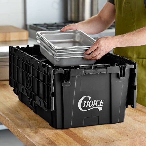 A man putting food in a black Choice stackable chafer tote.
