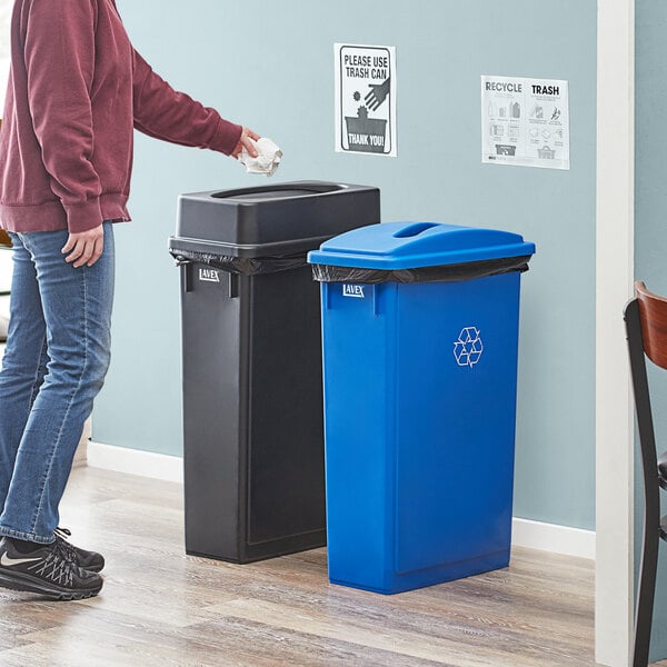 A man standing next to a Lavex 2-Stream Recycle Station with blue and black lids.