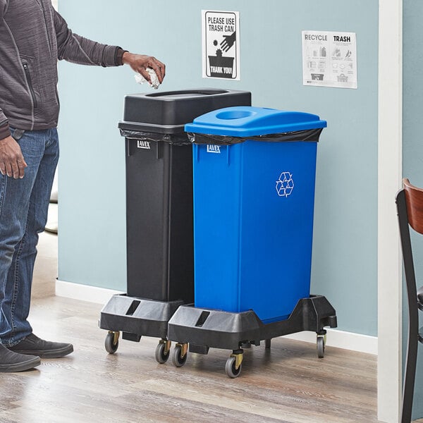 A man standing next to a Lavex 2-Stream recycle station with a blue bottle/can lid on one side and a black drop shot lid on the other.