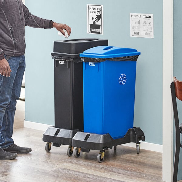 A man standing next to a Lavex 2-stream recycle station with black and blue lids.