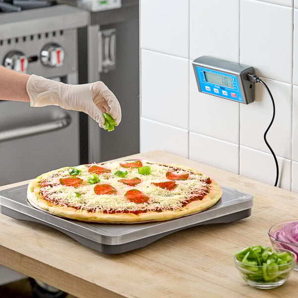 An AvaWeigh pizza scale on a counter in a pizza parlor.