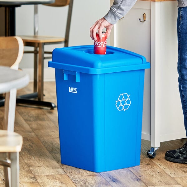 A man opening a blue Lavex recycle bin with a bottle/can lid.