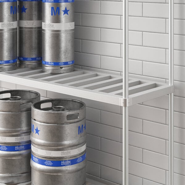 A metal Regency bottom shelf with beer kegs on it.